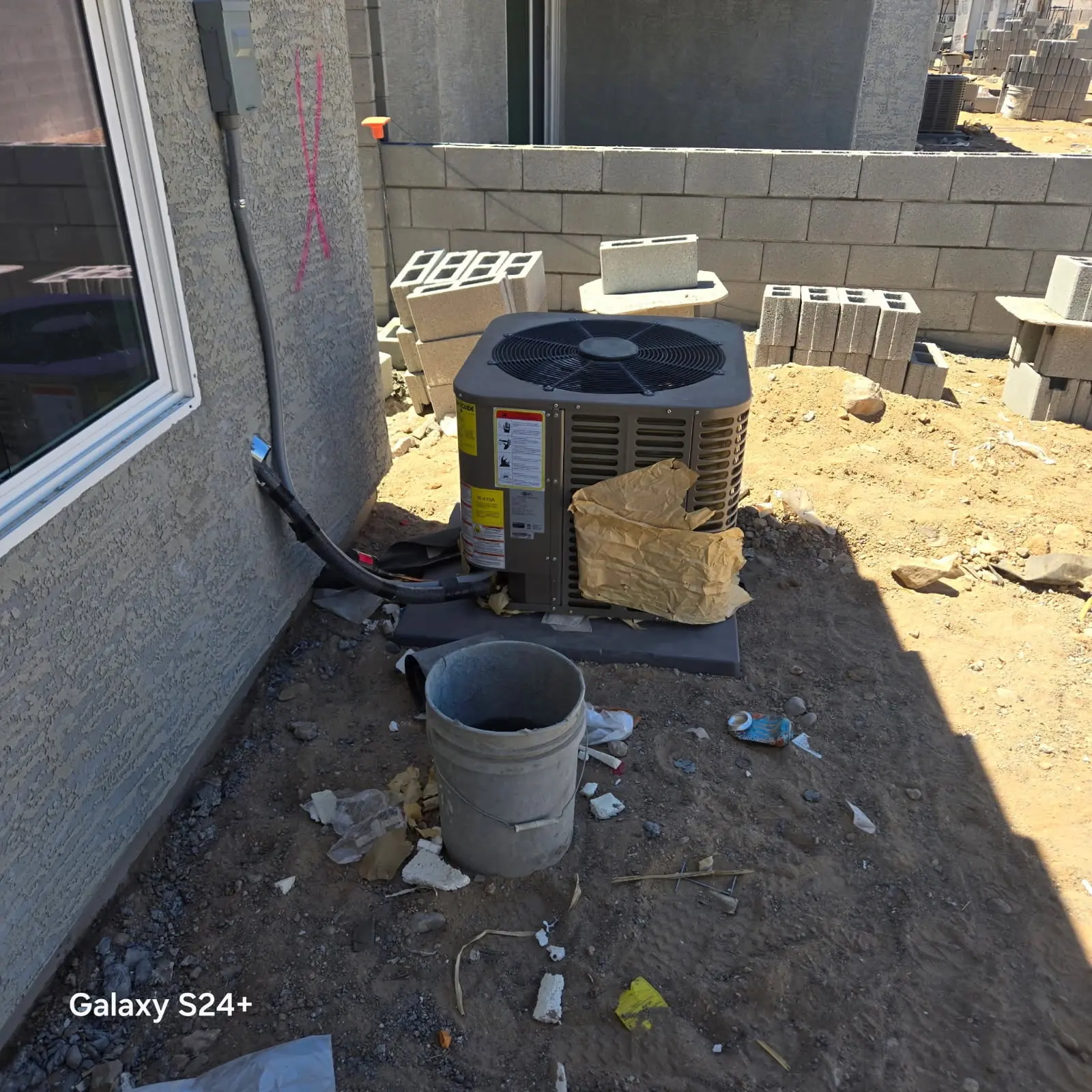 Technician taking readings at an outdoor condensing unit before an AC replacement recommendation
