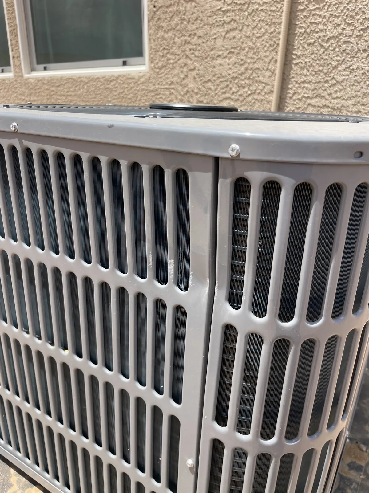 Technician servicing the top of an outdoor condensing unit