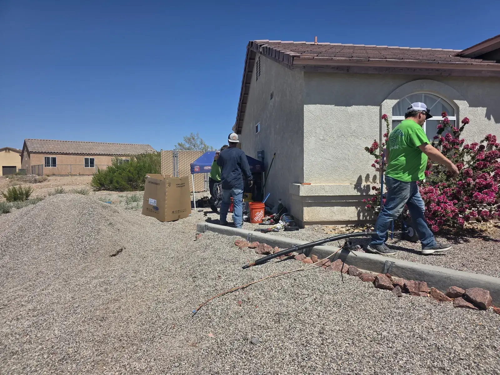 Comfort Air Solutions technicians working on equipment outside a desert home