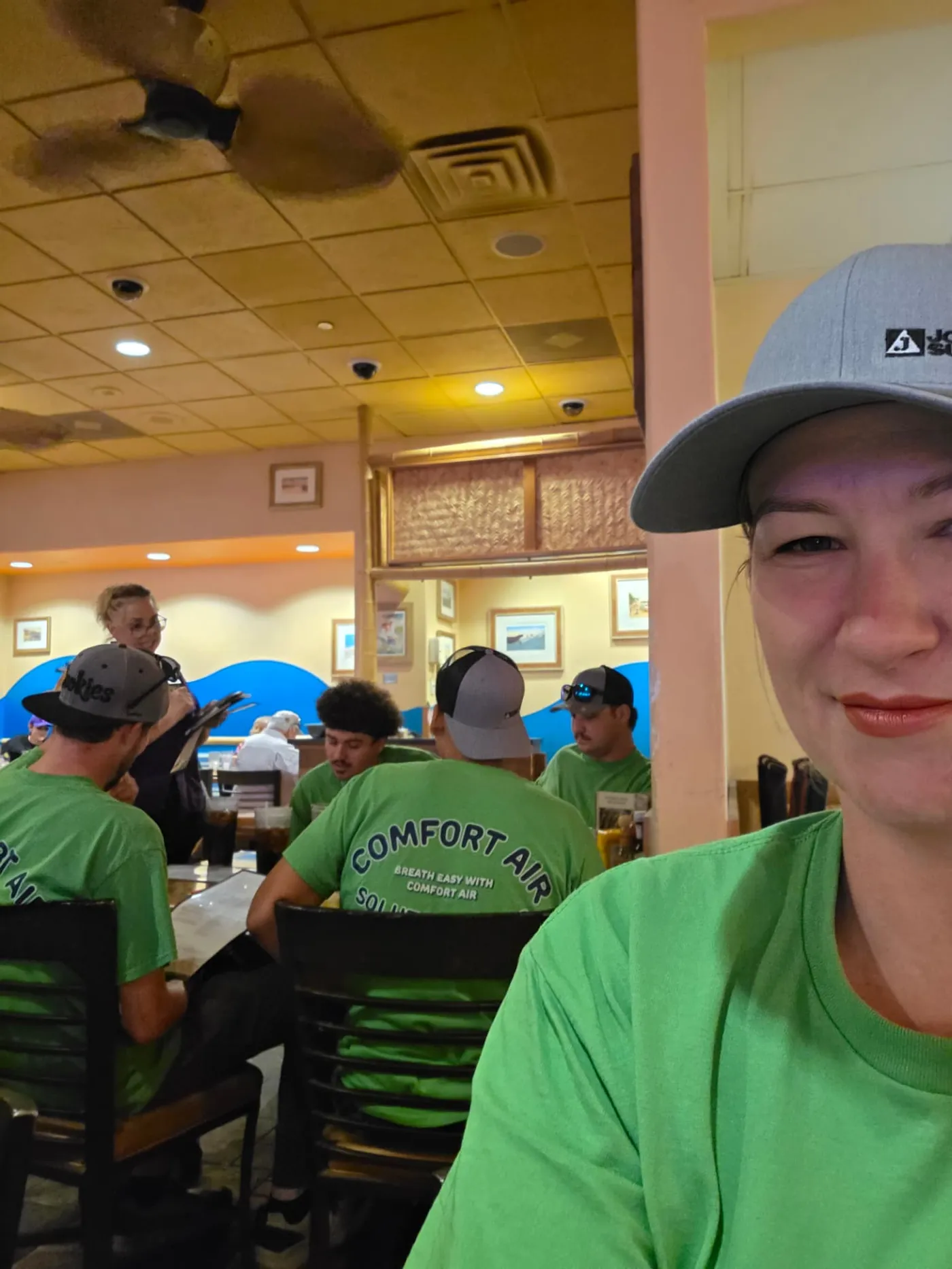 Comfort Air Solutions team members in company shirts sitting together at lunch
