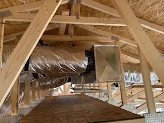 Flexible duct runs and a supply register boot in an attic