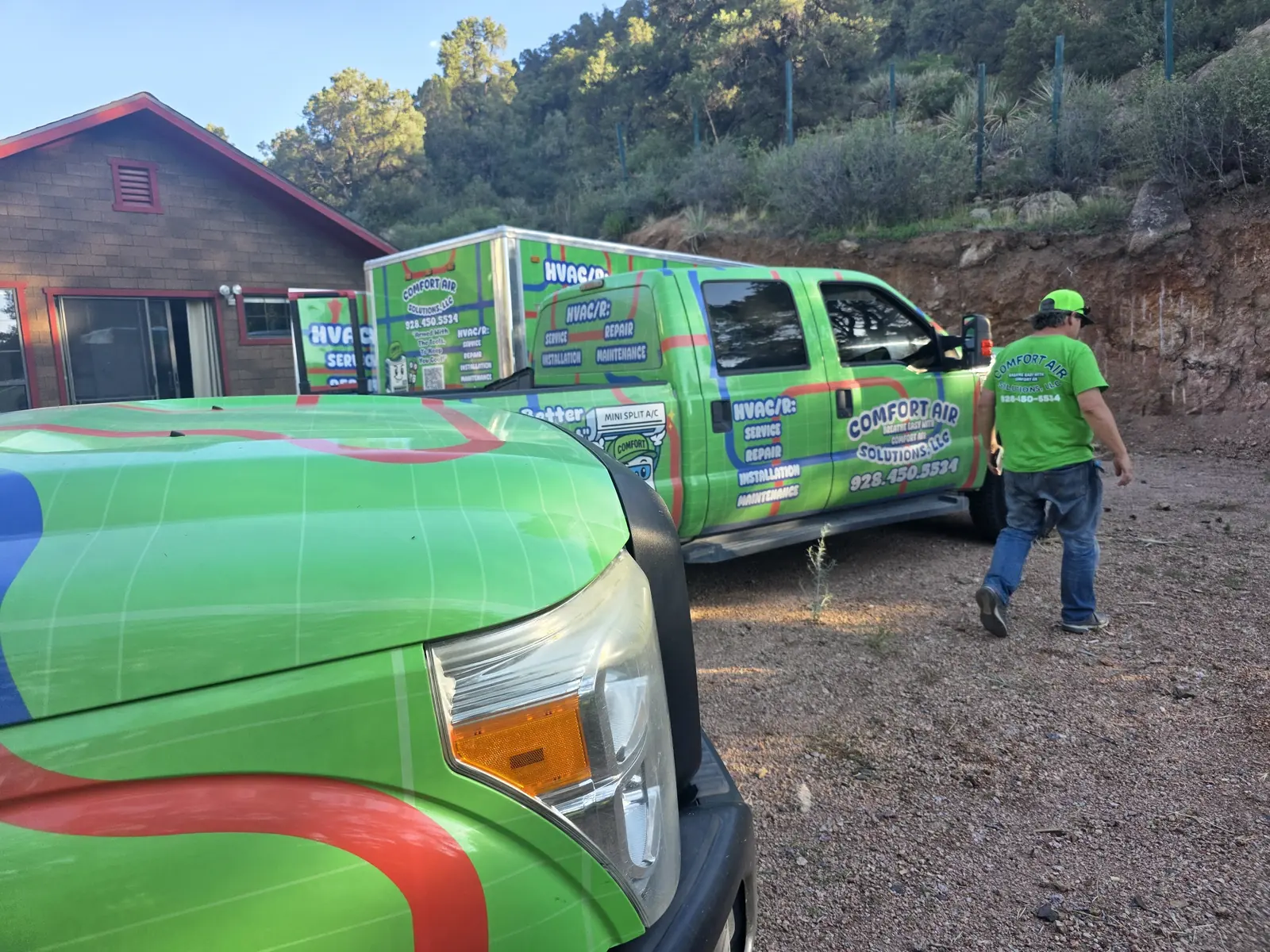Comfort Air Solutions trucks and technician at a property among pine trees