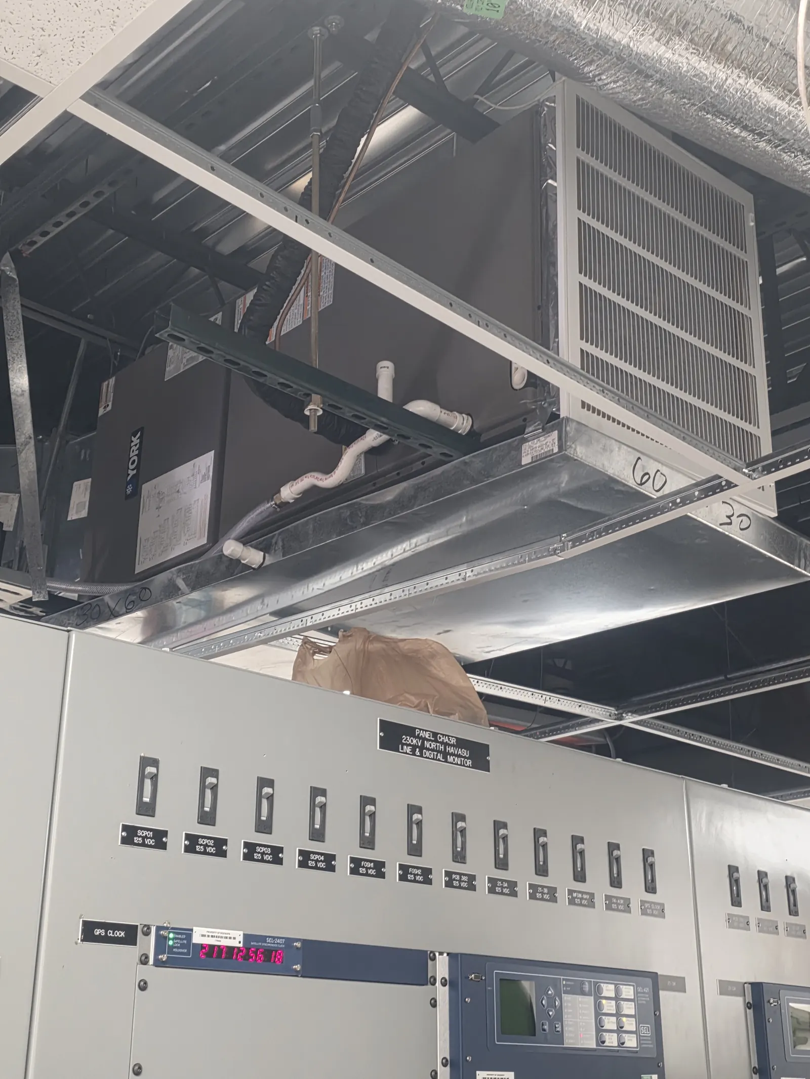 Commercial air handling equipment and electrical panel above a ceiling