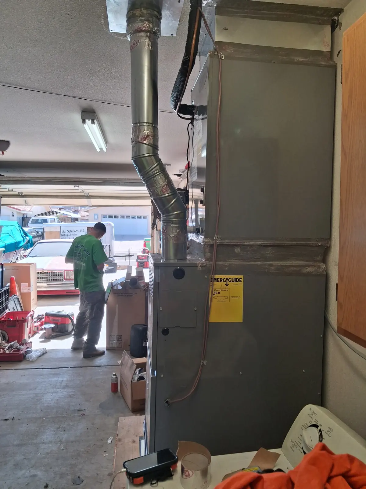 Comfort Air Solutions technician working on a furnace in a garage