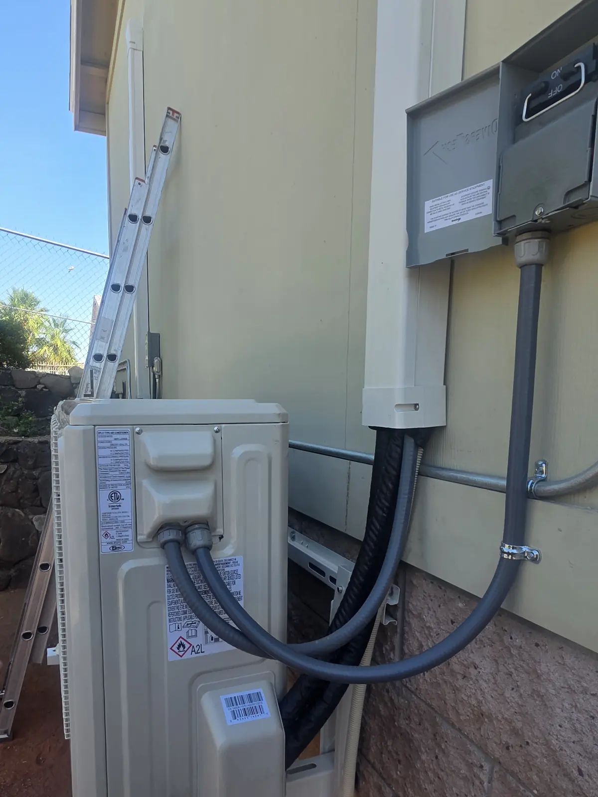 Outdoor heat pump unit with line set cover beside a home