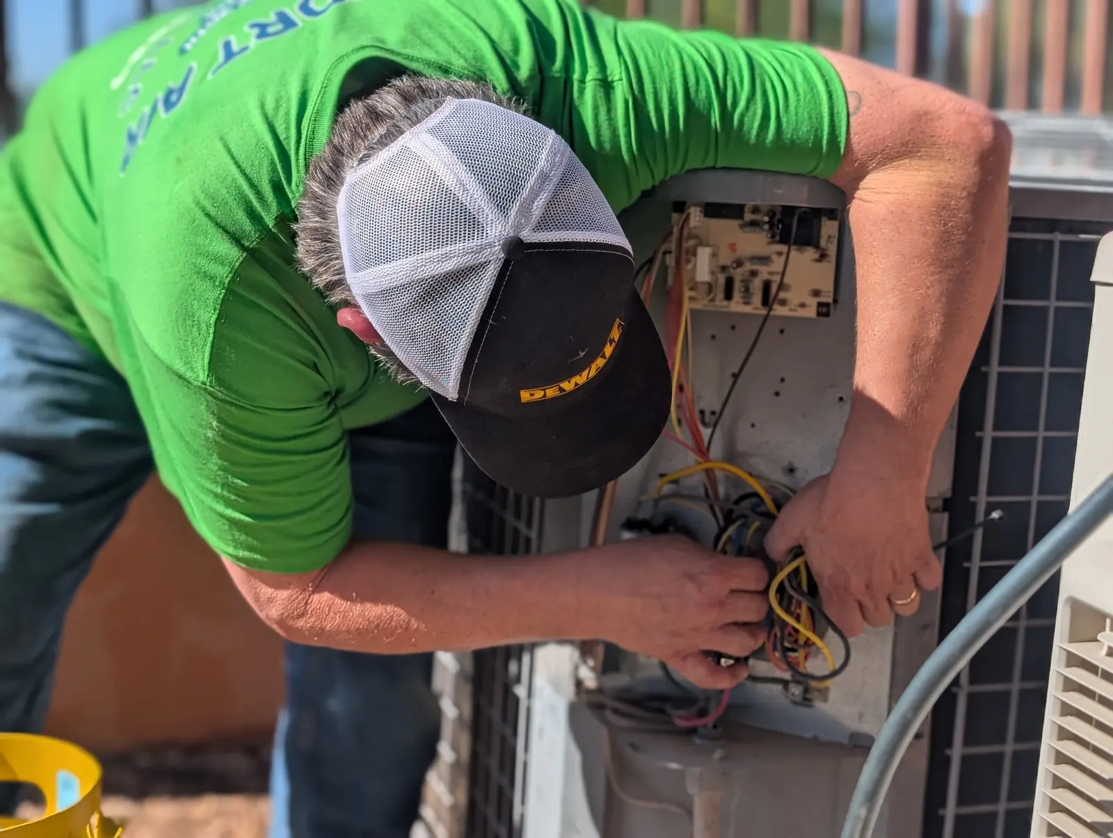 Comfort Air Solutions technician working on the wiring of an outdoor unit