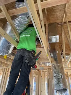 Comfort Air Solutions technician installing ductwork in a new home