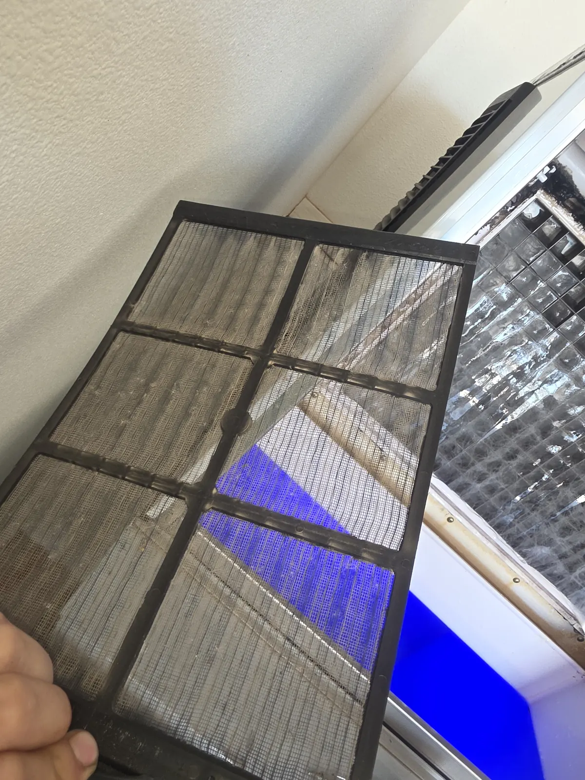 Technician checking an air filter during a maintenance visit