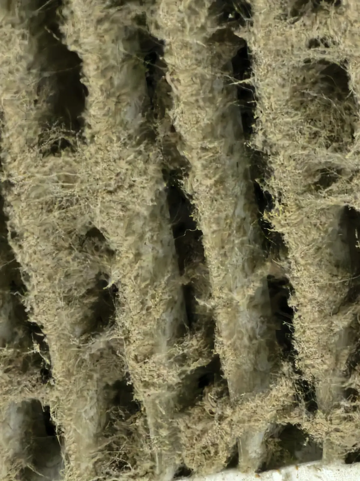 Dust and lint buildup on an HVAC coil found during maintenance