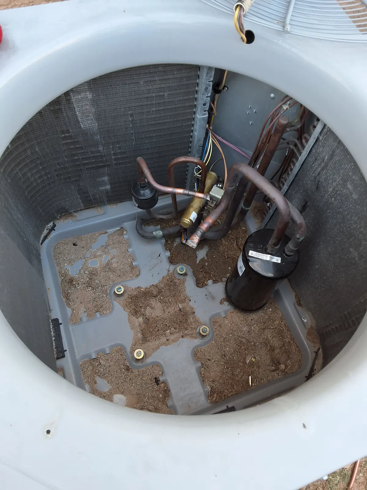 Technician servicing the top of an open condensing unit