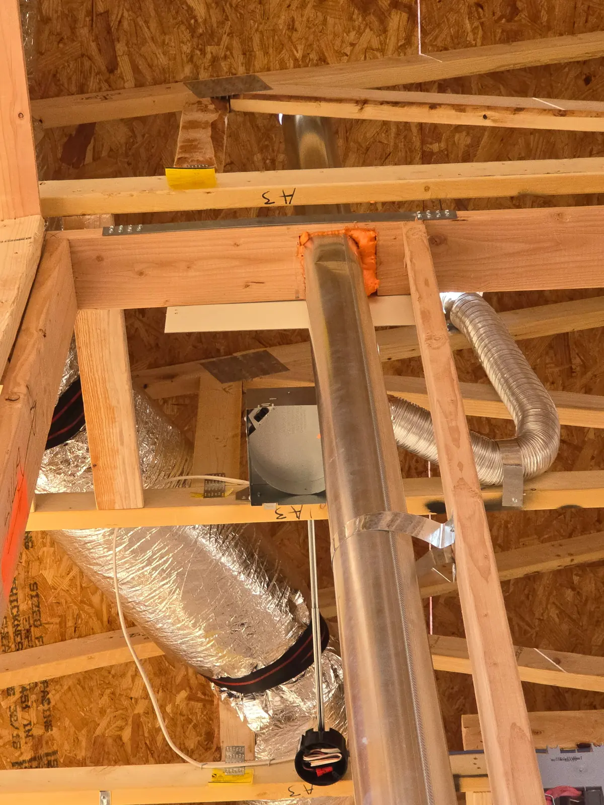 Flexible duct runs between attic trusses