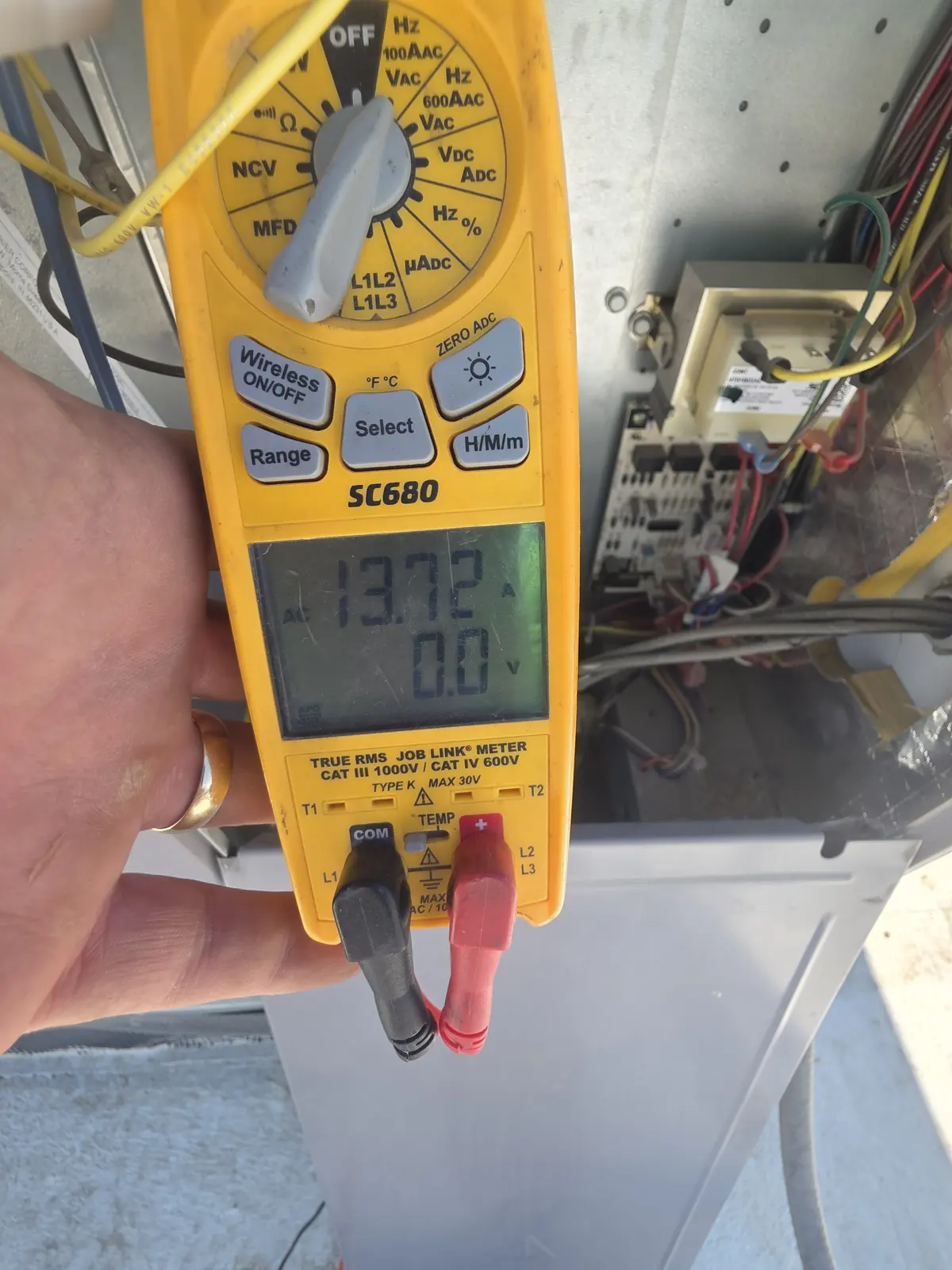 HVAC maintenance technician taking readings at an outdoor condensing unit